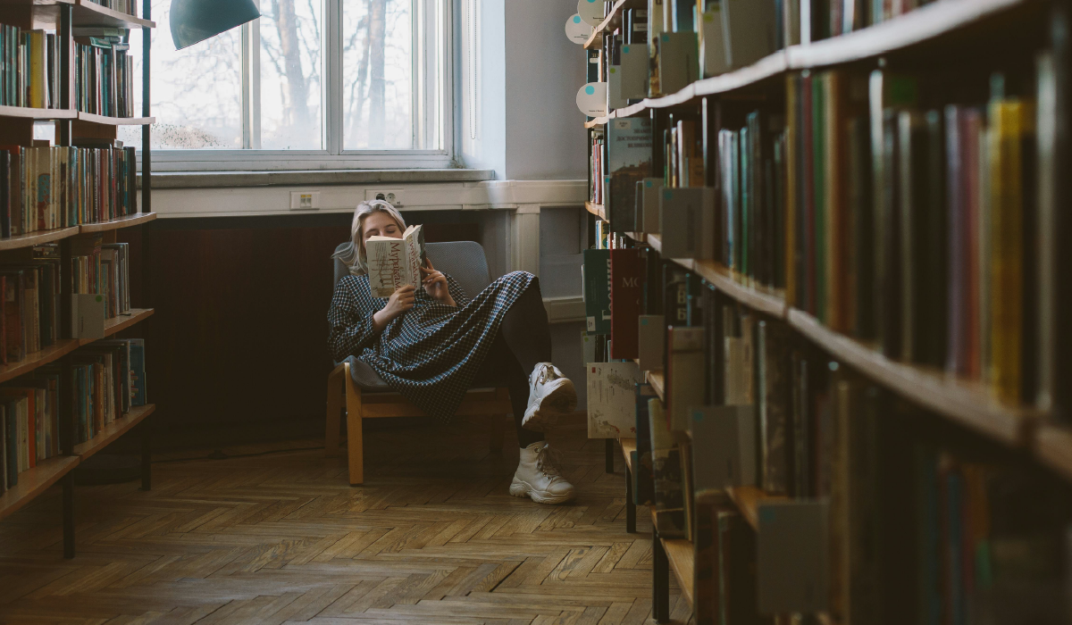Fotografía de una persona leyendo libros